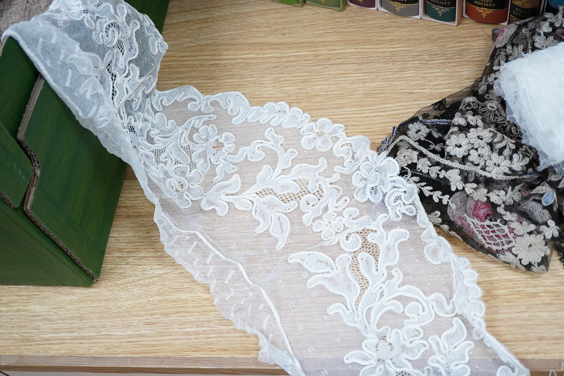 A collection of lace including black and coloured lace panels, mostly machine lace